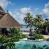 brown nipa hut near swimming pool during daytime