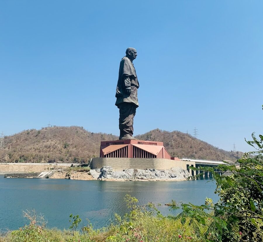 man in black jacket statue near body of water during daytime