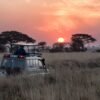 man riding on gray car during sunset