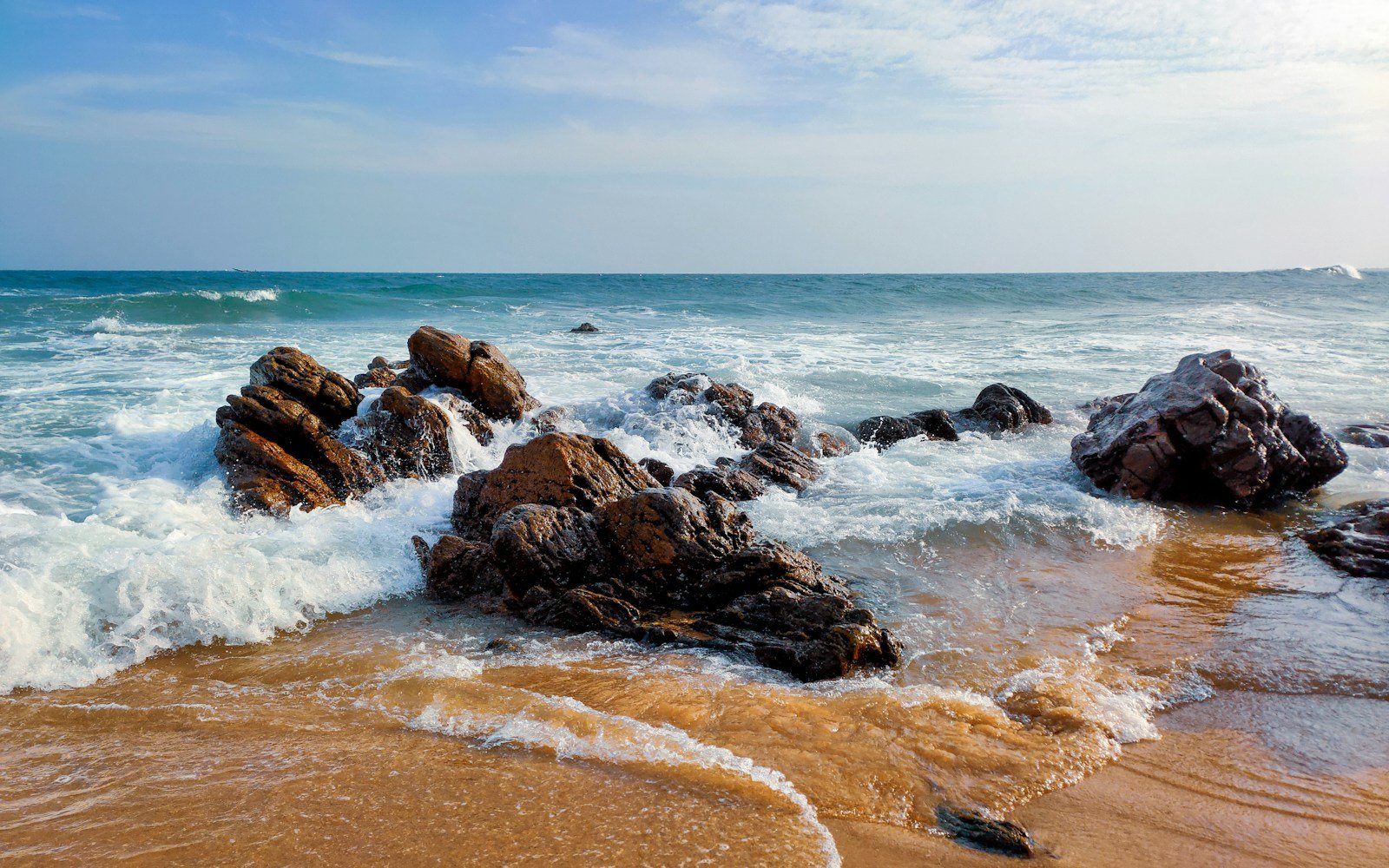 brown rocky shore under blue sky during daytime